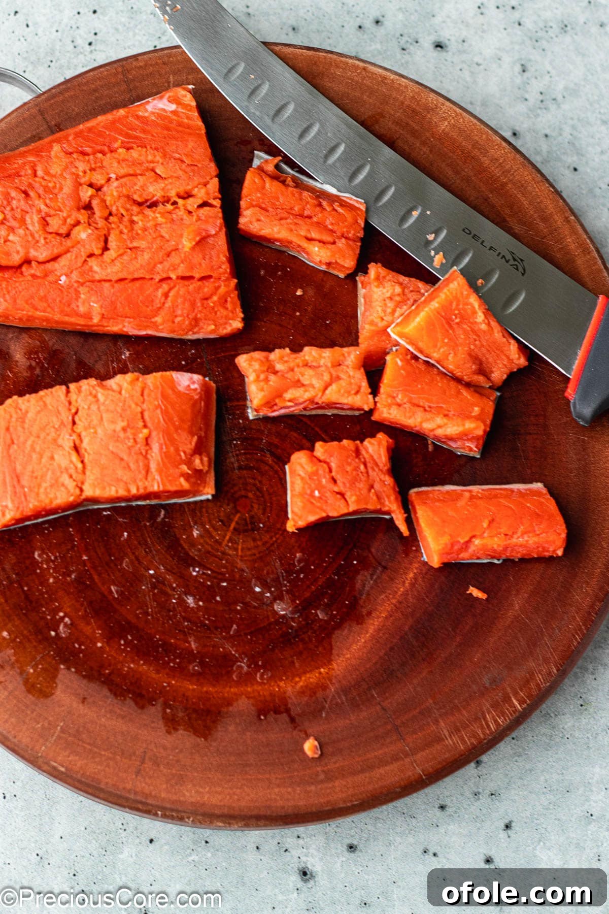 Irresistible Salmon Bites 5 Cut salmon pieces on a chopping board, ready for seasoning.