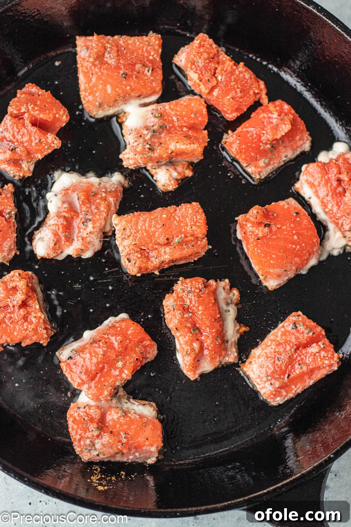 Irresistible Salmon Bites 7 Crispy salmon bites sizzling in a hot cast iron skillet.