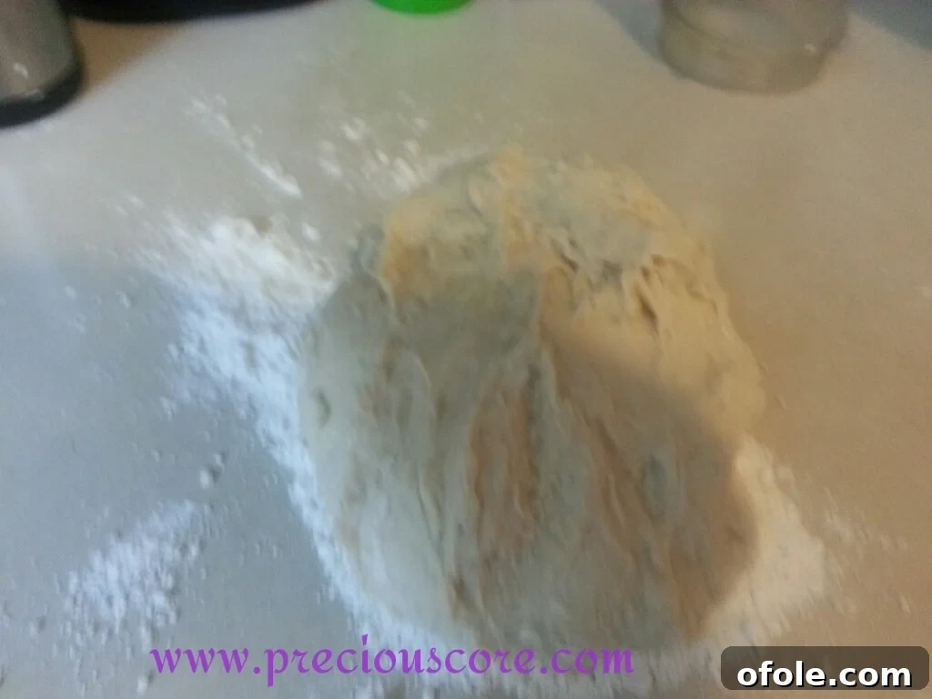 Essential Kneading for a Smooth Kumba Bread Dough Kneading Kumba Bread dough on a floured surface for gluten development