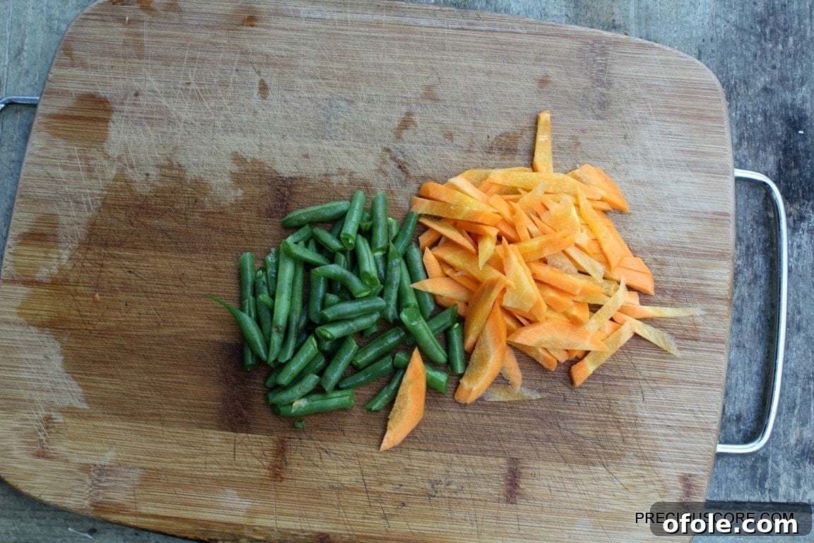 Freshly chopped carrots and green beans, ready to be added to the soup