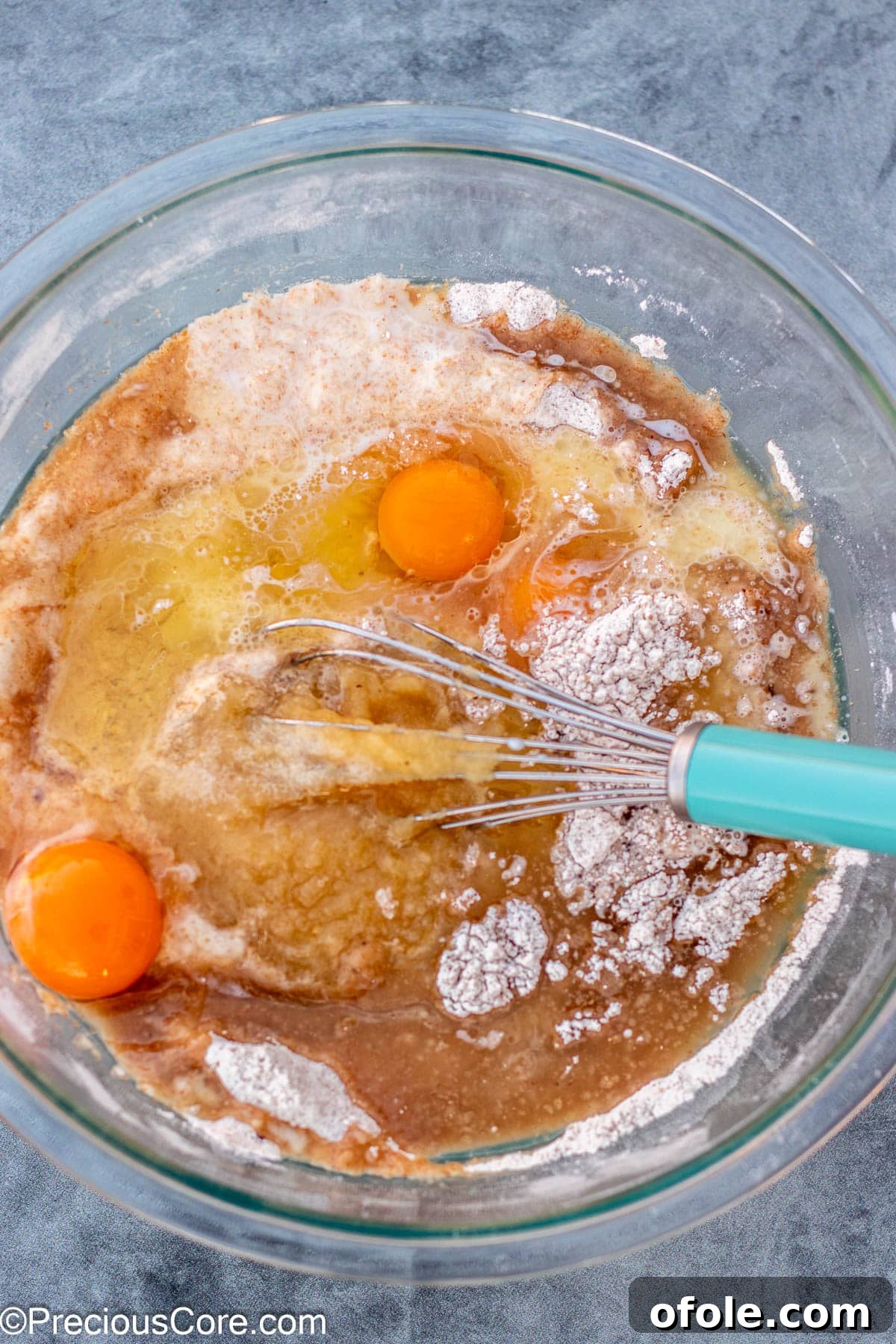 Wet ingredients for muffins added to the dry mixture in a bowl.