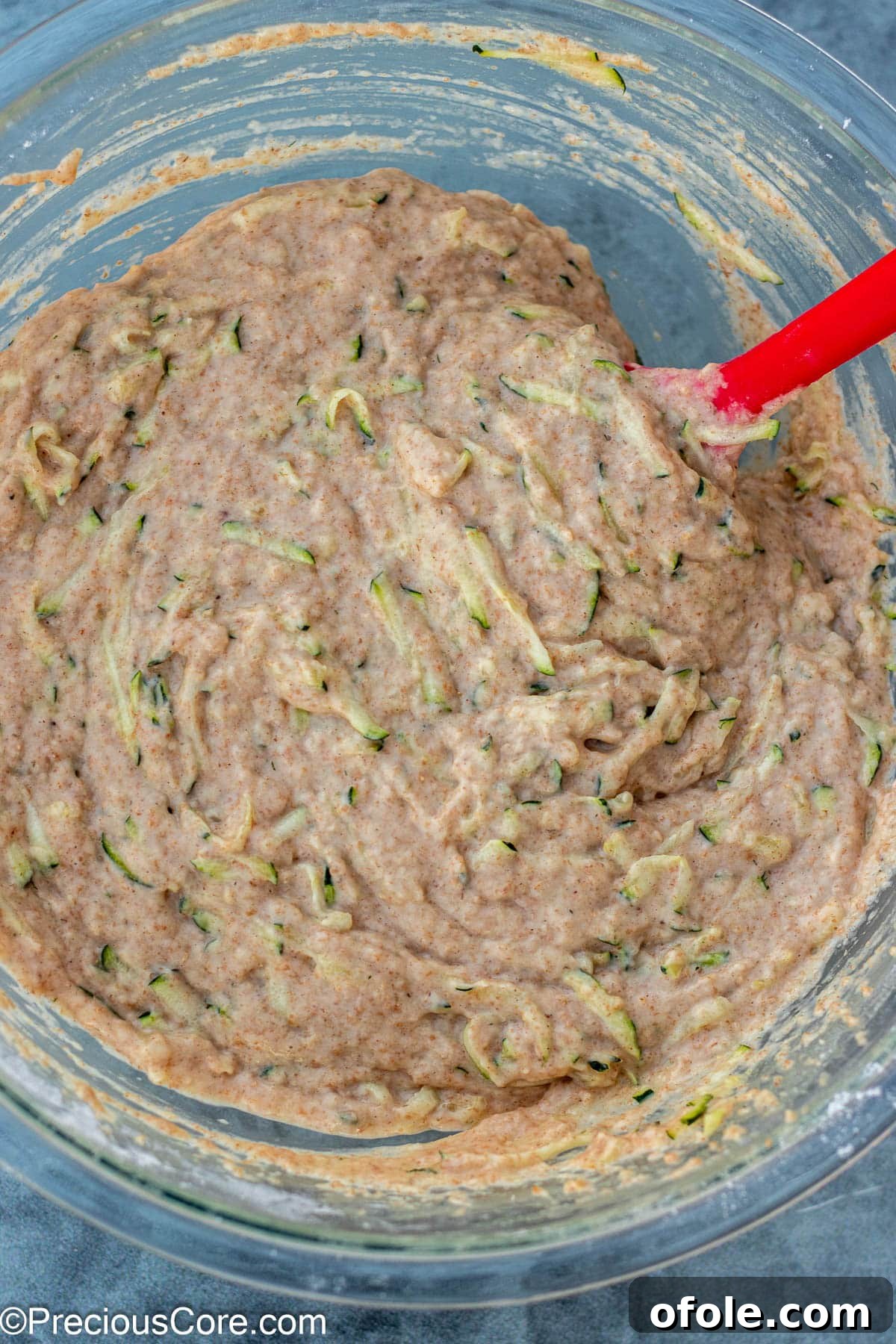 Complete zucchini muffin batter with shredded zucchini folded in, ready for baking.
