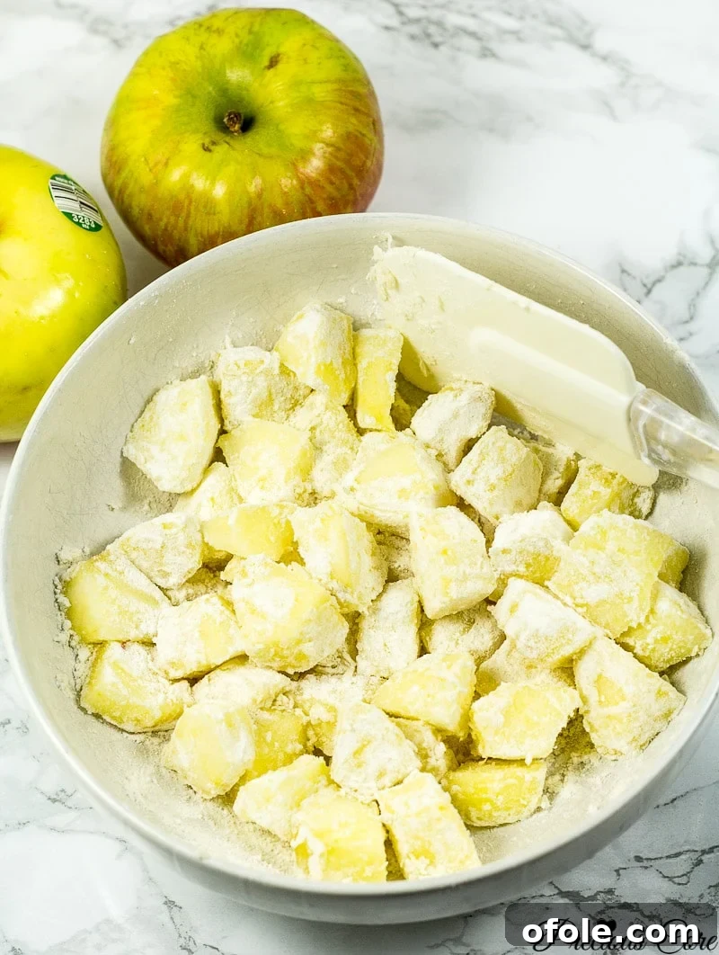 Timeless Fresh Apple Cake 6 Close-up of apple chunks evenly coated with flour, ready for the cake batter.