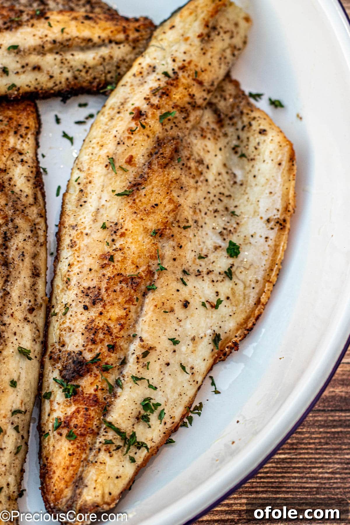 Pan Seared Sea Bass garnished with fresh parsley, ready to serve.
