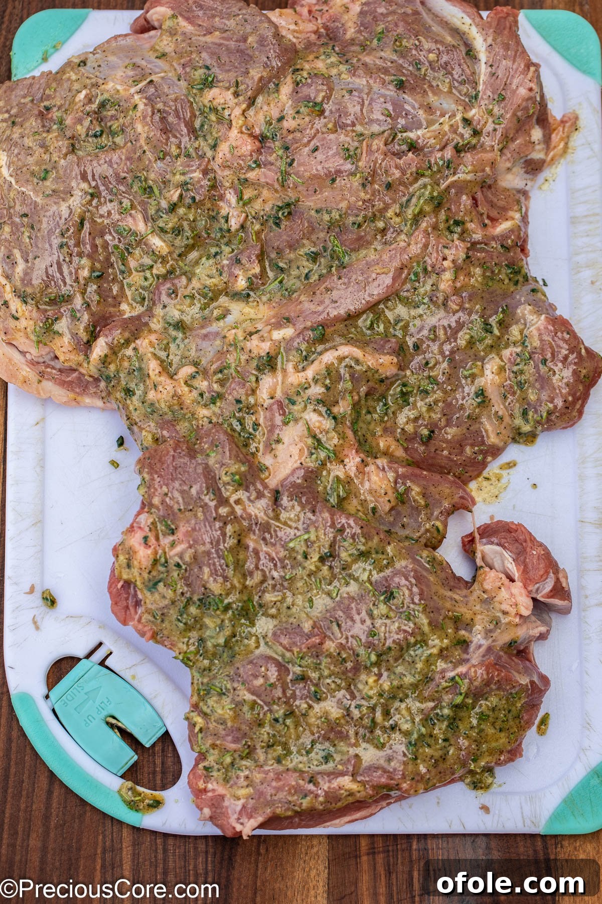 A large piece of butterflied lamb leg generously brushed with a herb and garlic marinade.