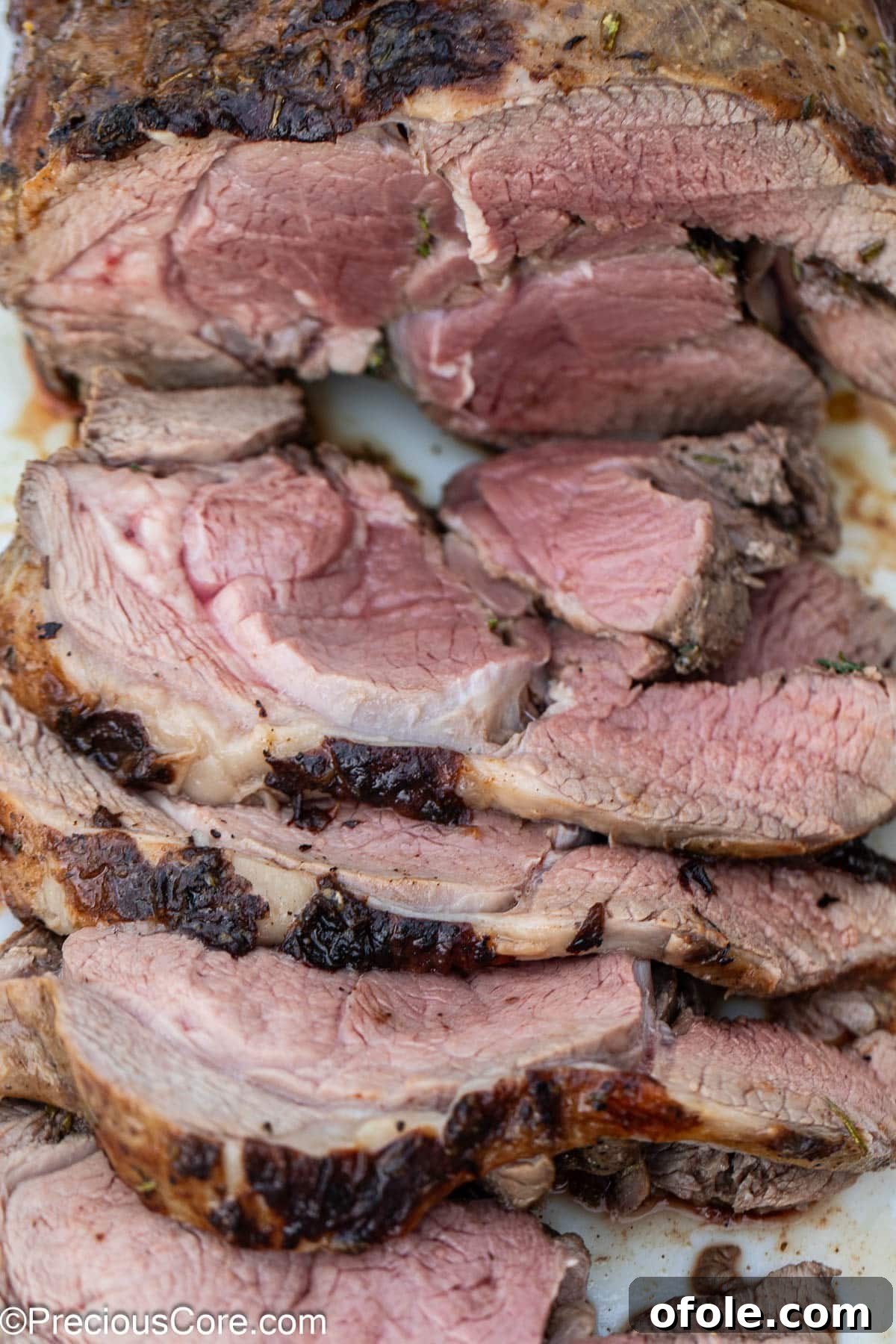 Close-up of freshly sliced roasted lamb, showcasing its tender texture and perfect doneness.