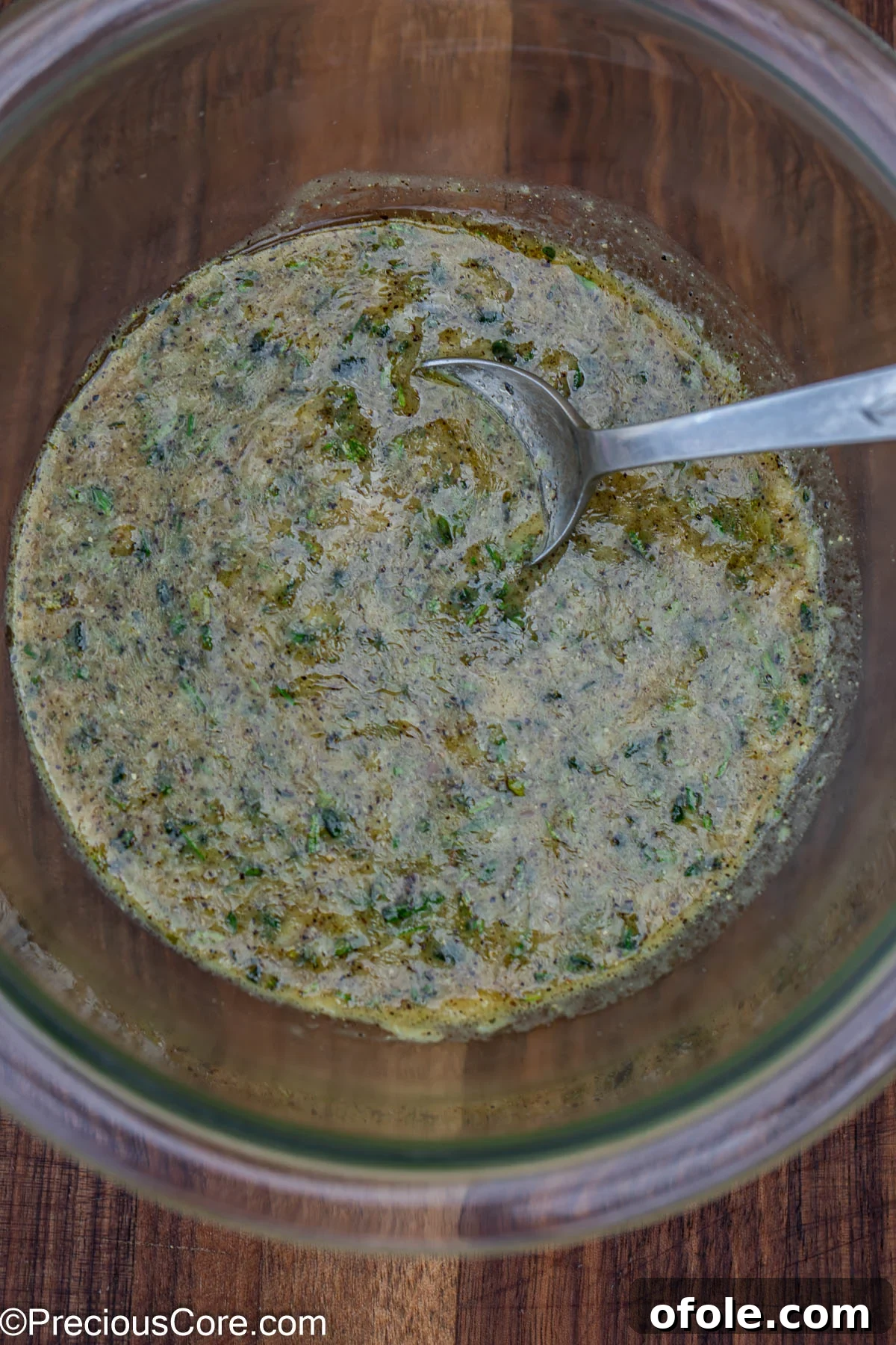 A close-up of the flavorful marinade mixture in a glass mixing bowl.