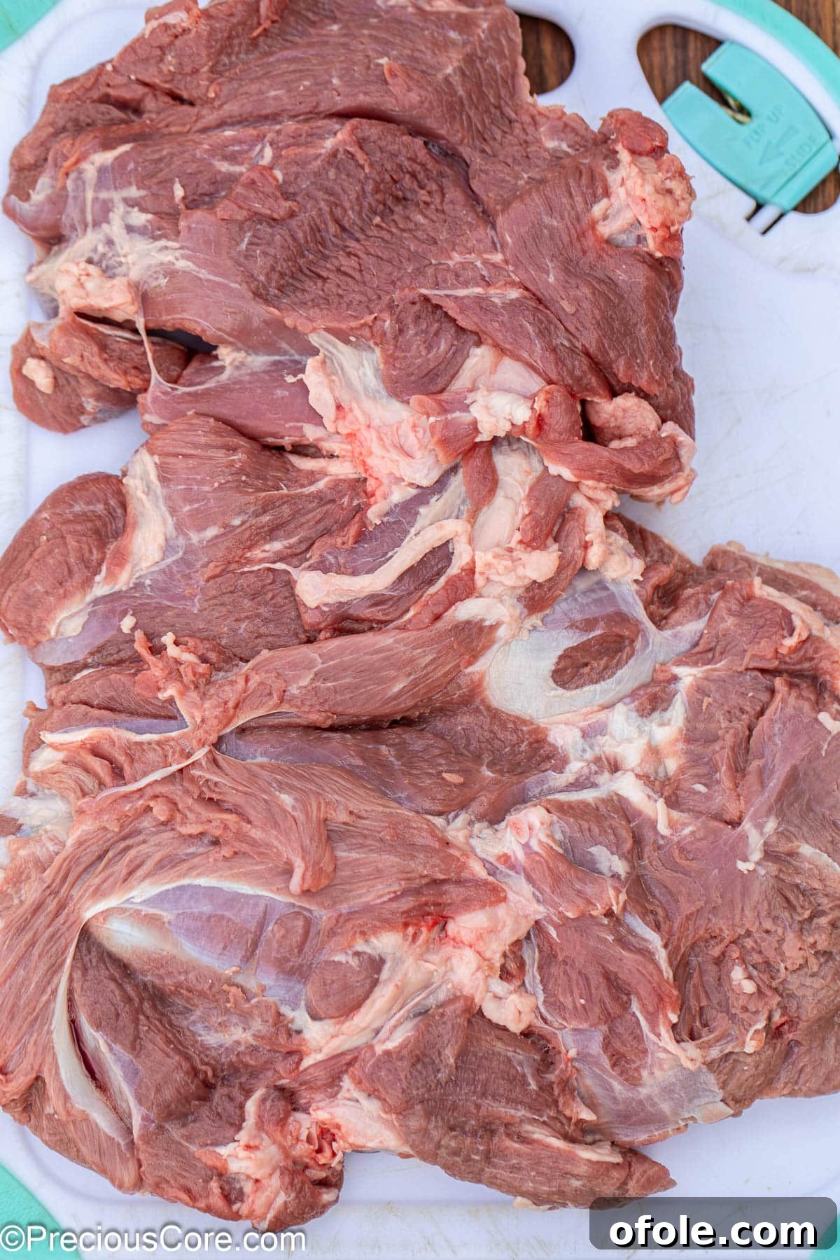 A boneless leg of lamb butterflied and laid flat on a cutting board.