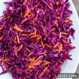 A vibrant and freshly prepared red cabbage slaw, artfully presented on a serving platter.