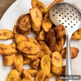 Perfectly golden-brown sweet fried plantains, neatly arranged on a paper towel after cooking to absorb excess oil.