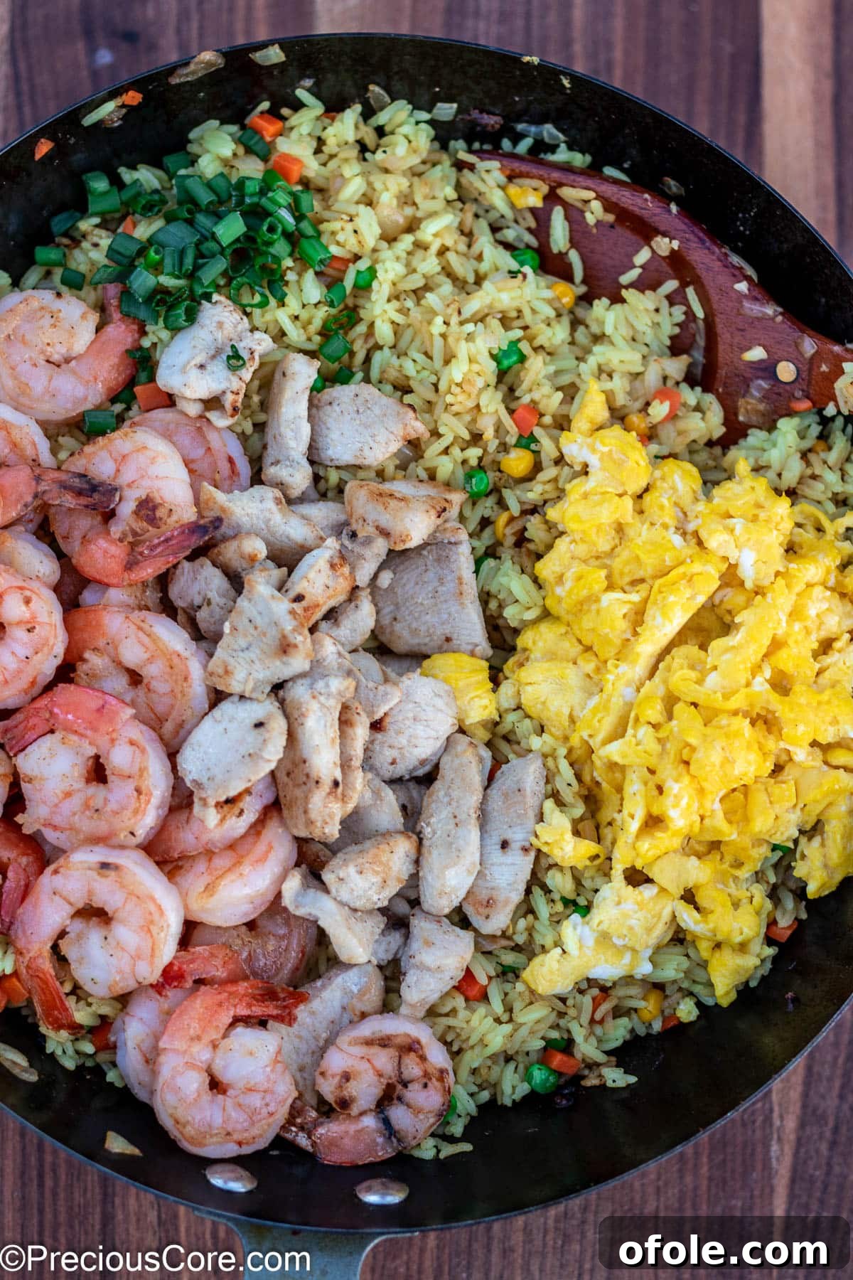 Signature Surf & Turf Fried Rice 12 Fried rice topped with shrimp and chicken, nearly complete.