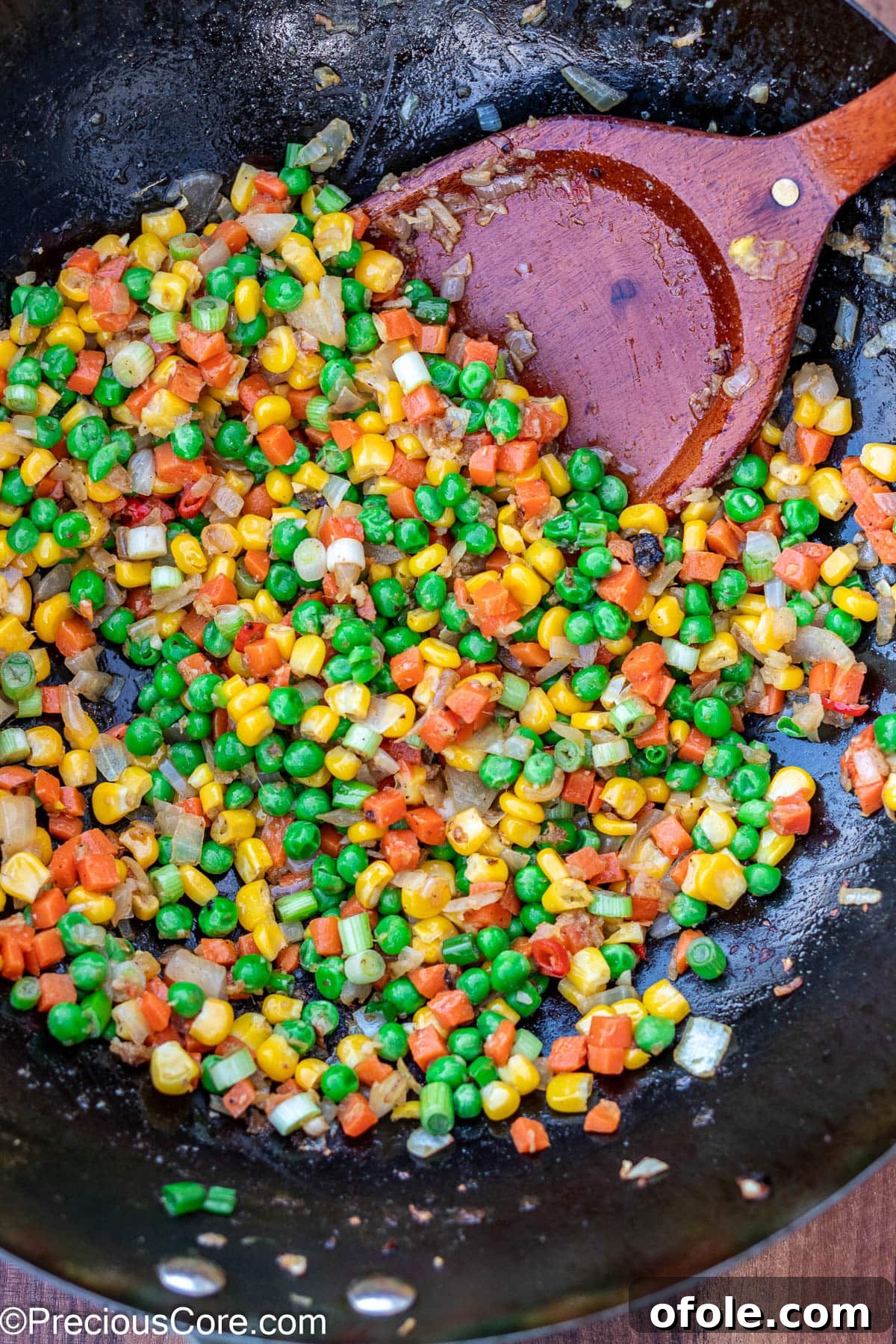 Signature Surf & Turf Fried Rice 10 Vegetables stir-frying in a wok with aromatics.