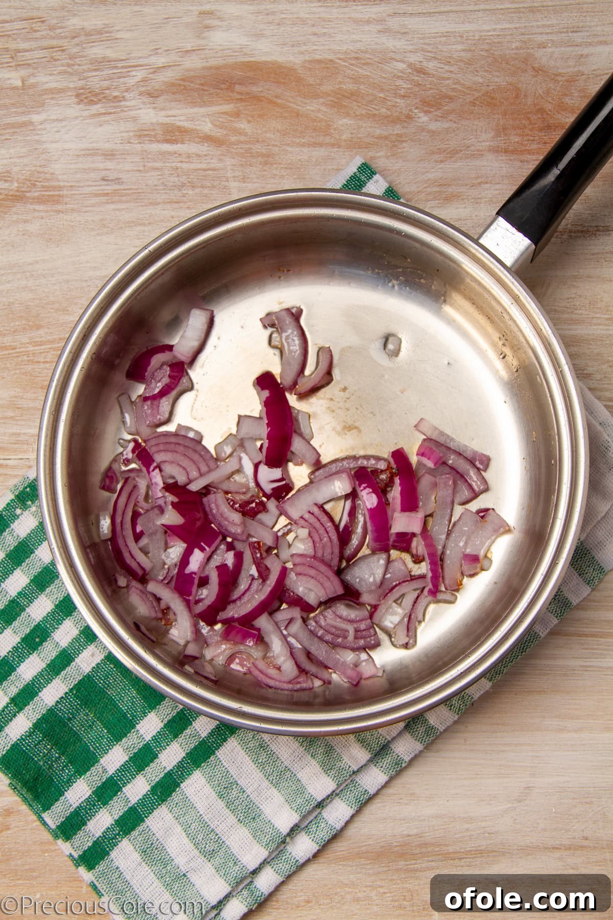 Homemade Mushroom Pizza Perfection 11 Sliced onions sautéing in a pan with olive oil, becoming translucent.
