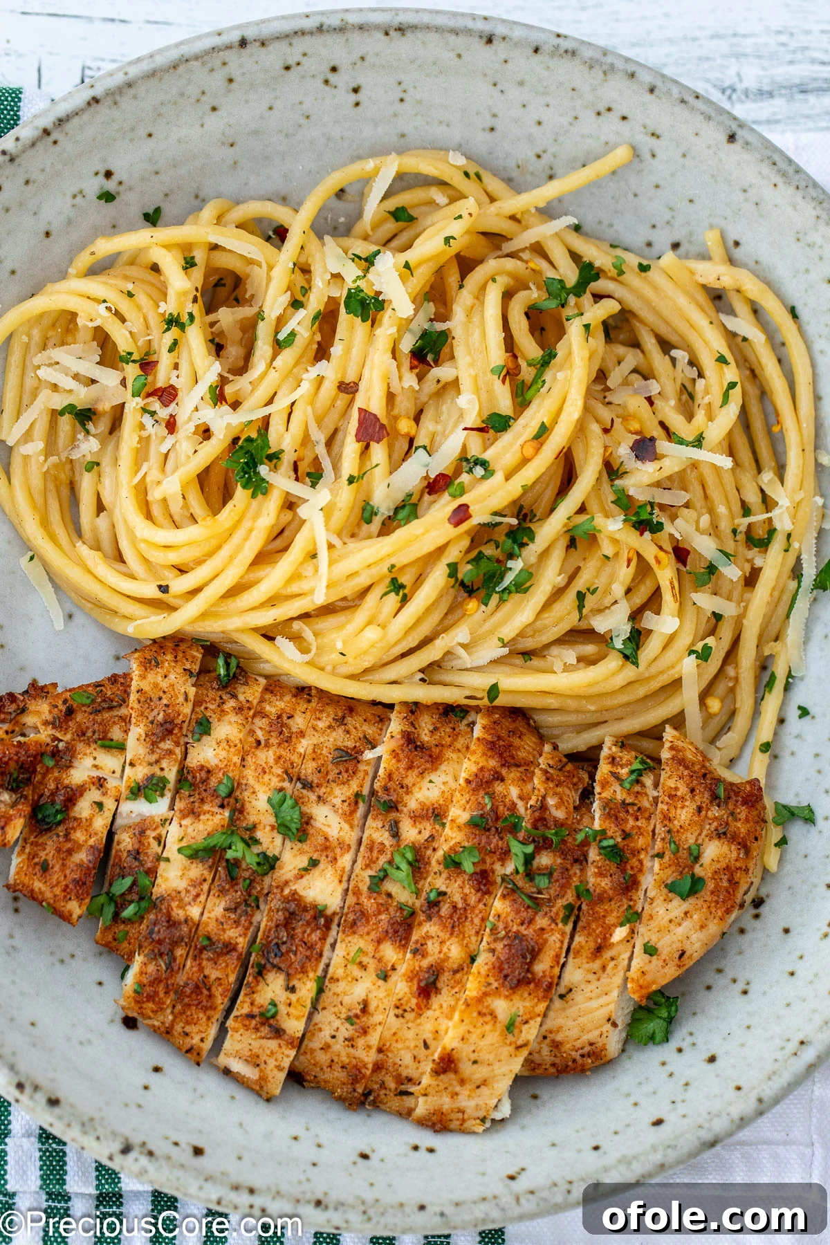A bowl of delectable garlic butter pasta, topped with perfectly cooked chicken breasts, ready to be served.