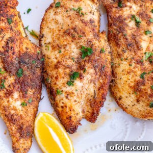 Thin sliced chicken breasts served with lemon wedges.