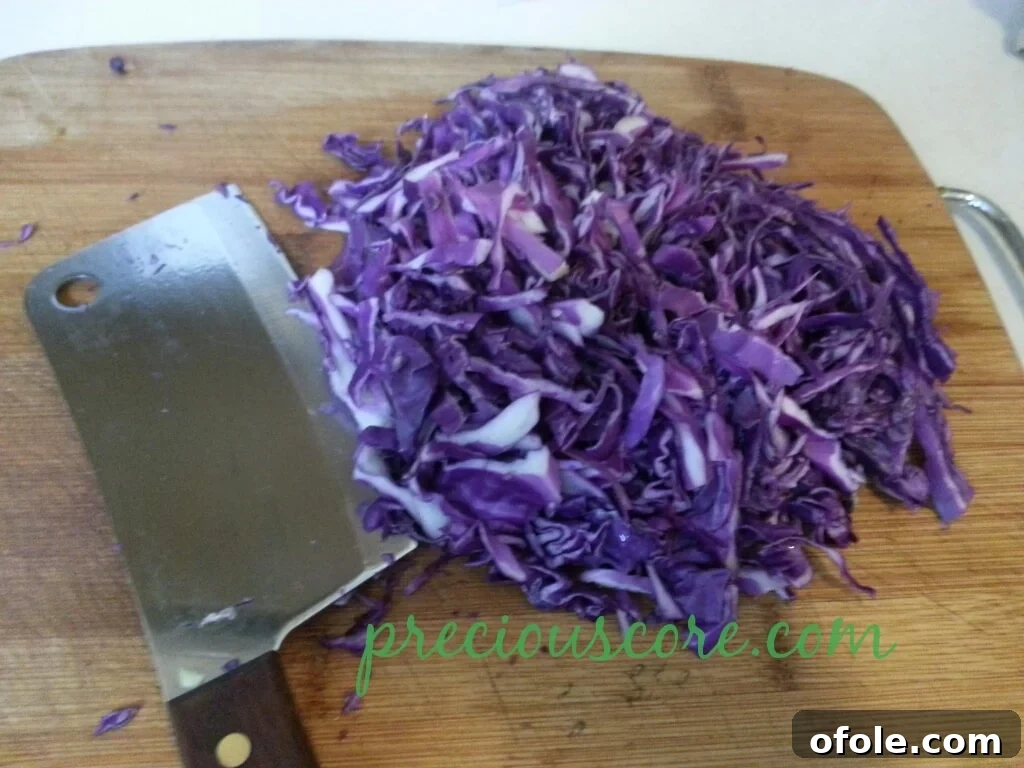 Vibrant Cameroon Salad with Authentic Dressing 2 Finely shredded red cabbage laid out on a tray.