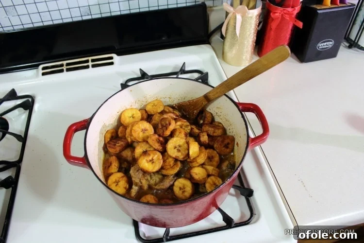 Ultimate Poulet DG Recipe 15 Plantains in a red Dutch oven with chicken.