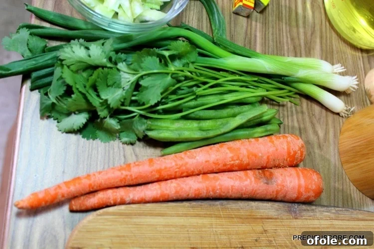 Ultimate Poulet DG Recipe 9 Carrots, green beans, and other produce on a wooden cutting board.