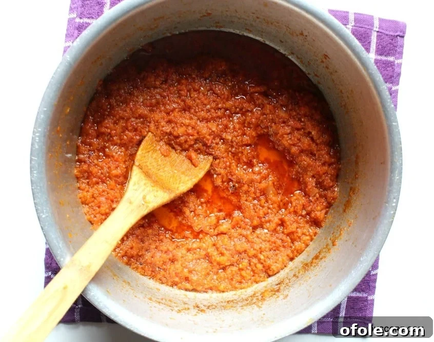cameroon-tomato-sauce - A pot of rich, simmering tomato sauce with onions and spices.