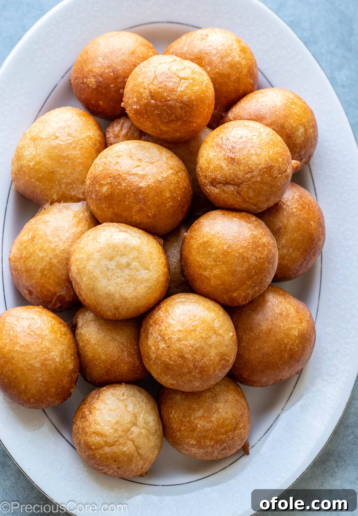 Homemade Fluffy Puff Puff 2 Freshly fried golden Puff Puff piled on a white tray, showcasing its appealing texture.