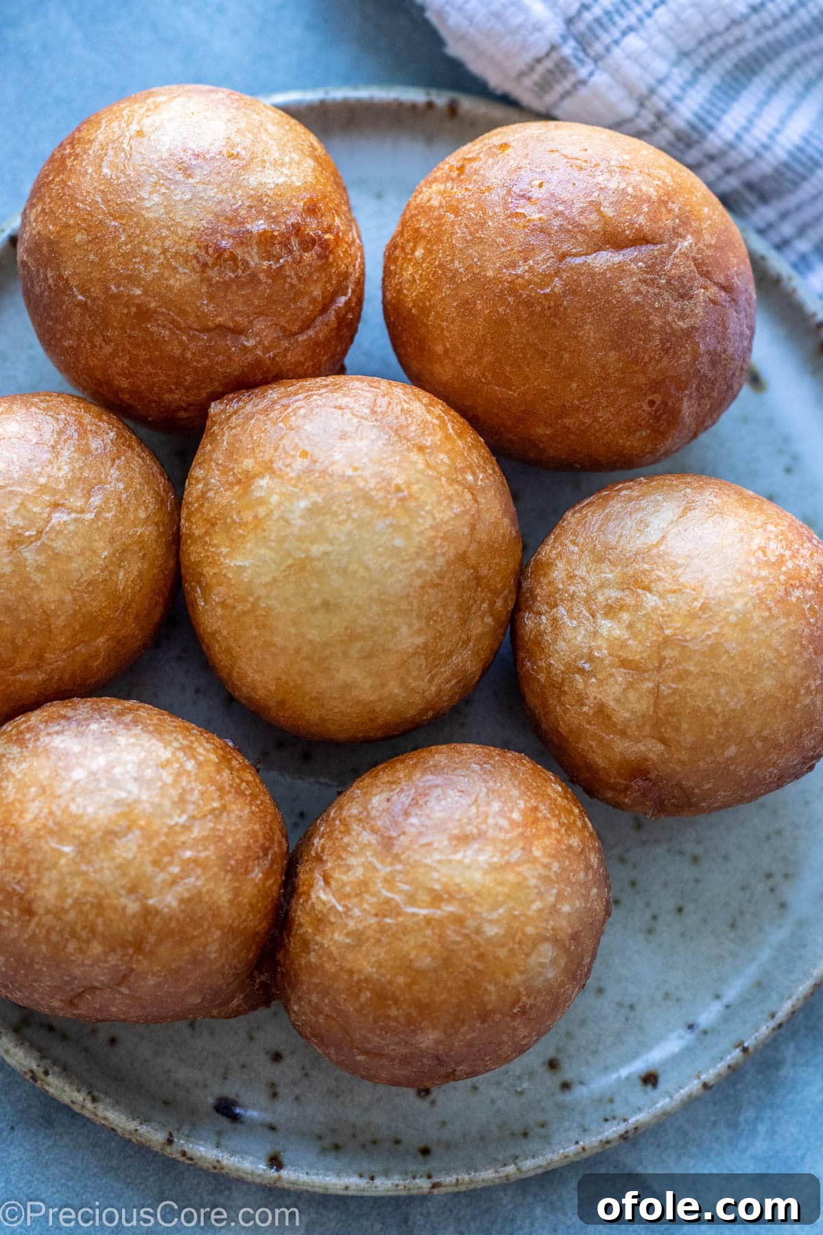 Homemade Fluffy Puff Puff 3 A plate of golden brown Puff Puff, perfectly round and ready to enjoy.