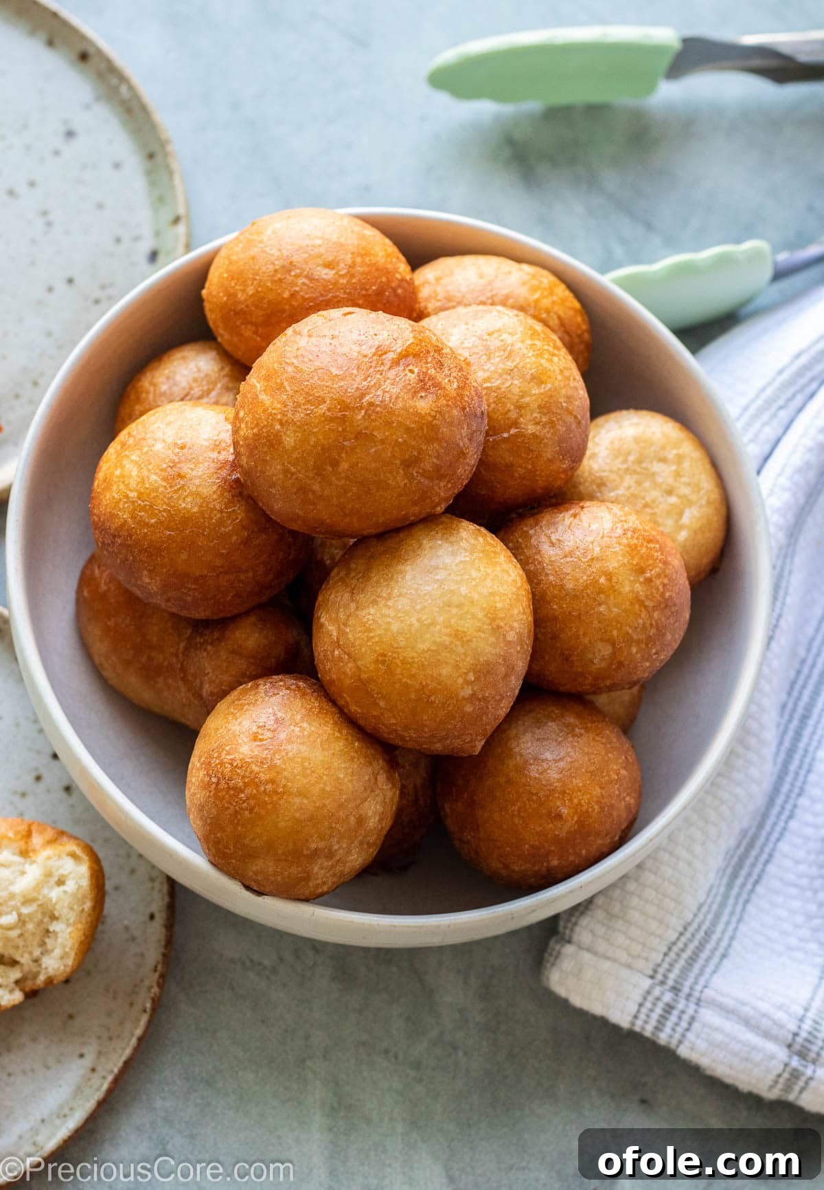 Homemade Fluffy Puff Puff 6 A large bowl overflowing with freshly fried, golden Puff Puff balls, showcasing their perfect round shape.