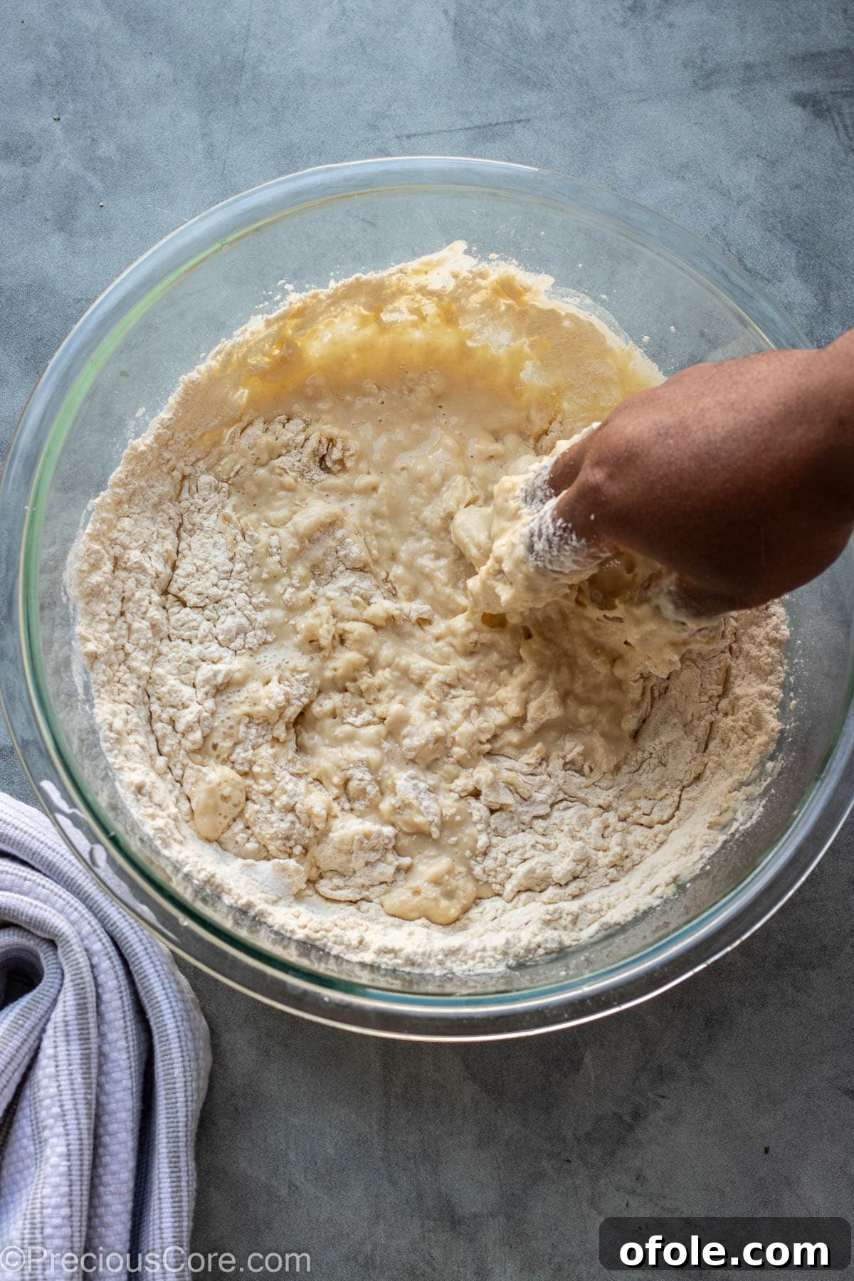Homemade Fluffy Puff Puff 9 A hand expertly mixing Puff Puff batter in a bowl, ensuring a smooth consistency.