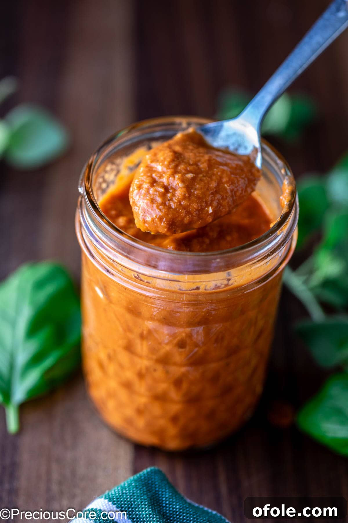 Slow Roasted Tomato Pizza Sauce 10 A spoon scooping a generous amount of roasted tomato pizza sauce.