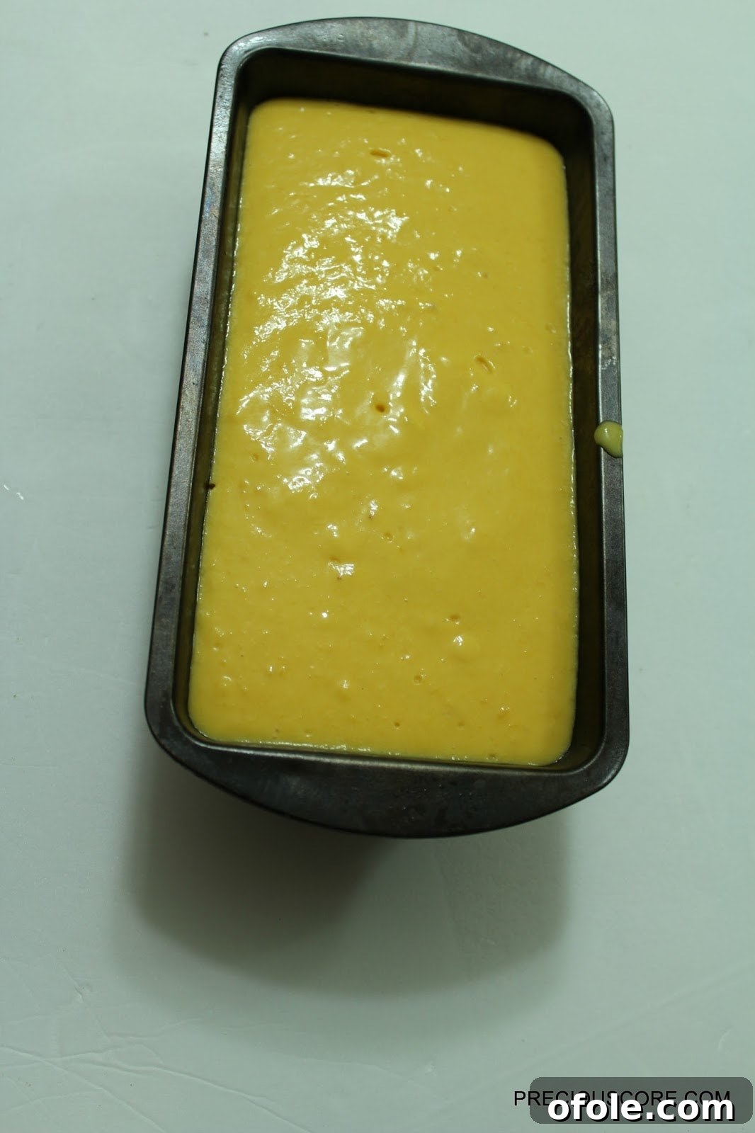 Mango coconut mixture in a loaf pan, ready for freezing