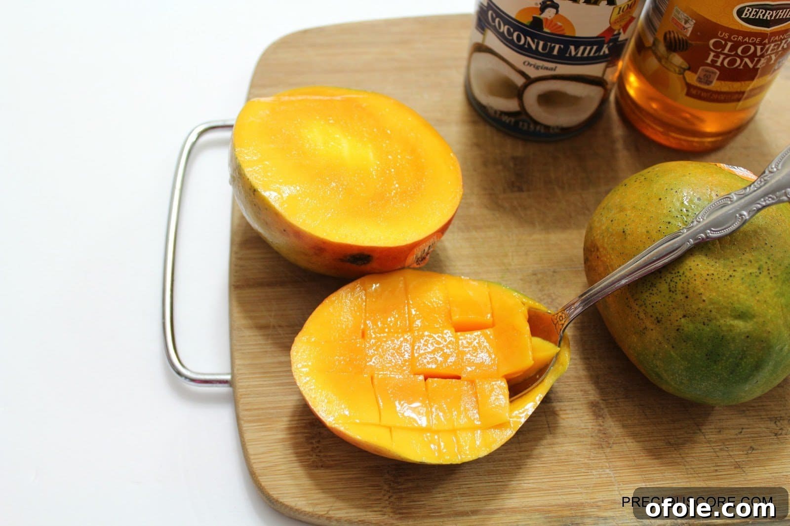 Scooping out diced mango from its skin