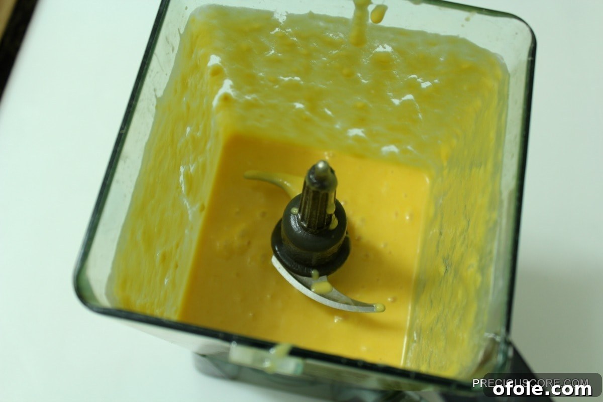 Smooth mango coconut mixture in a blender