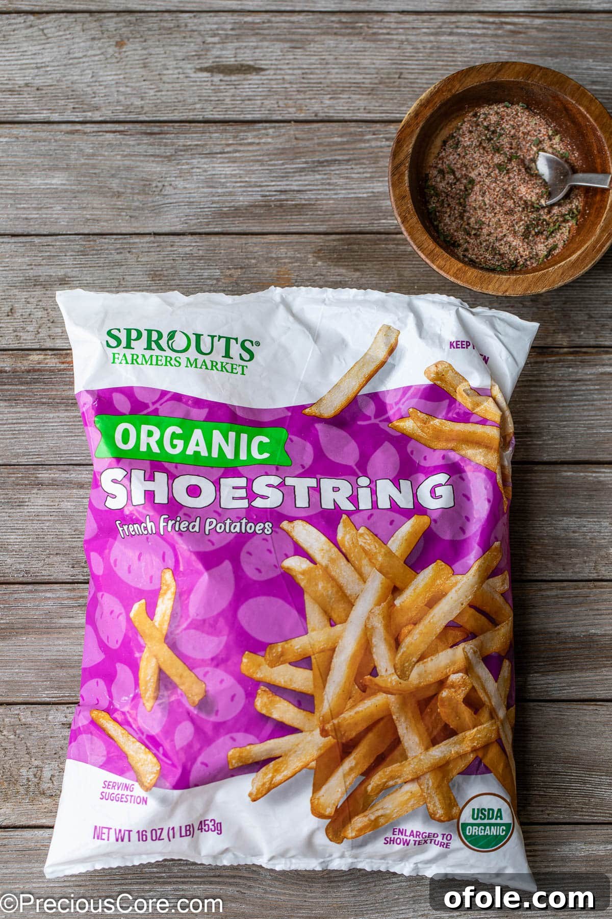 Effortless Crispy Fries in Your Air Fryer 3 A bag of frozen potato fries next to a small bowl of fry seasoning, ready for cooking.