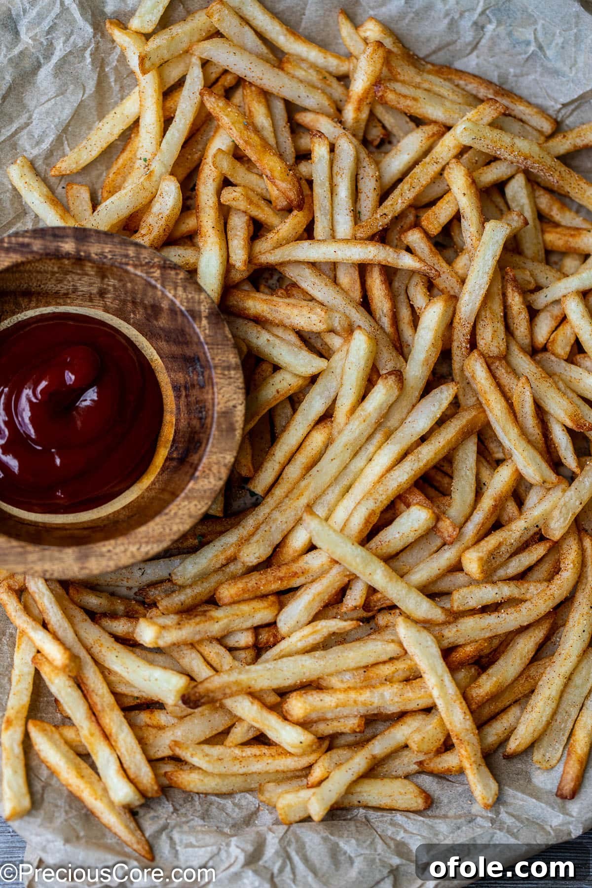 Effortless Crispy Fries in Your Air Fryer 5 Close-up of golden, crispy air-fried fries on a plate with a dollop of ketchup nearby.