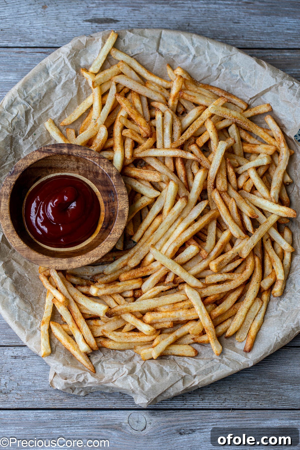 Effortless Crispy Fries in Your Air Fryer 6 Crispy air-fried fries served on a round platter, with a small bowl of ketchup on the side.