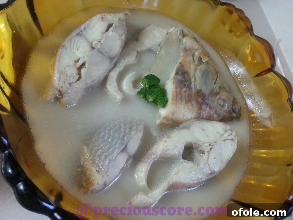 Fresh ingredients like fish, spices, and vegetables laid out for preparing pepper soup