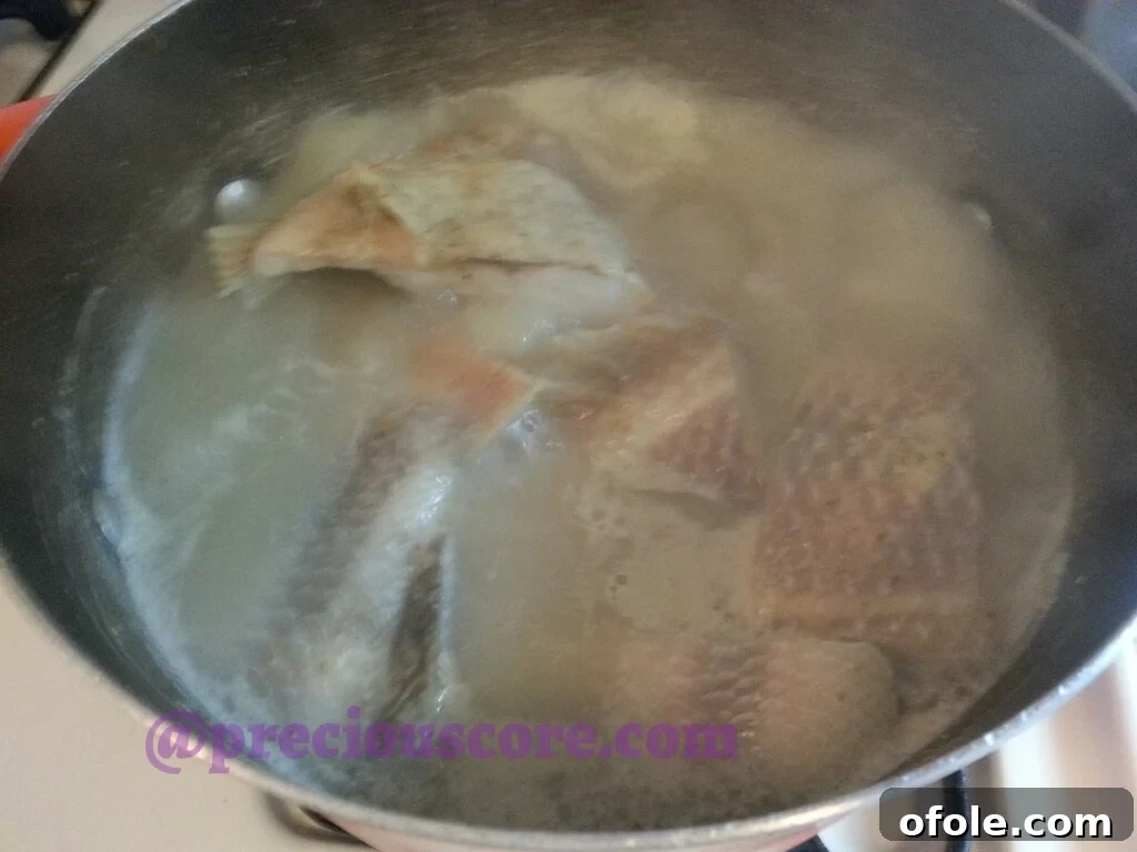 A beautifully garnished bowl of Cameroonian Fish Pepper Soup, ready to be served