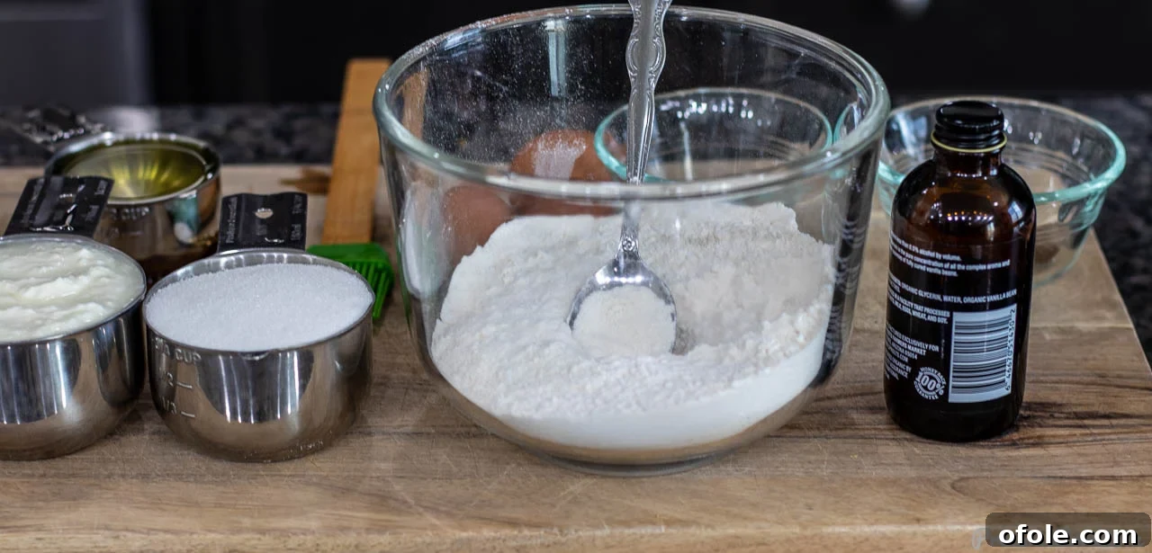 All the essential ingredients for making yogurt cake neatly arranged on a wooden chopping board.
