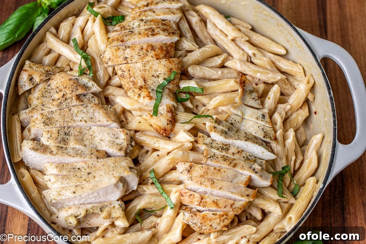 Parmesan Chicken Pasta with Garlic Cream Sauce 14 Landscape image of garlic parmesan creamy pasta beautifully topped with sliced chicken.