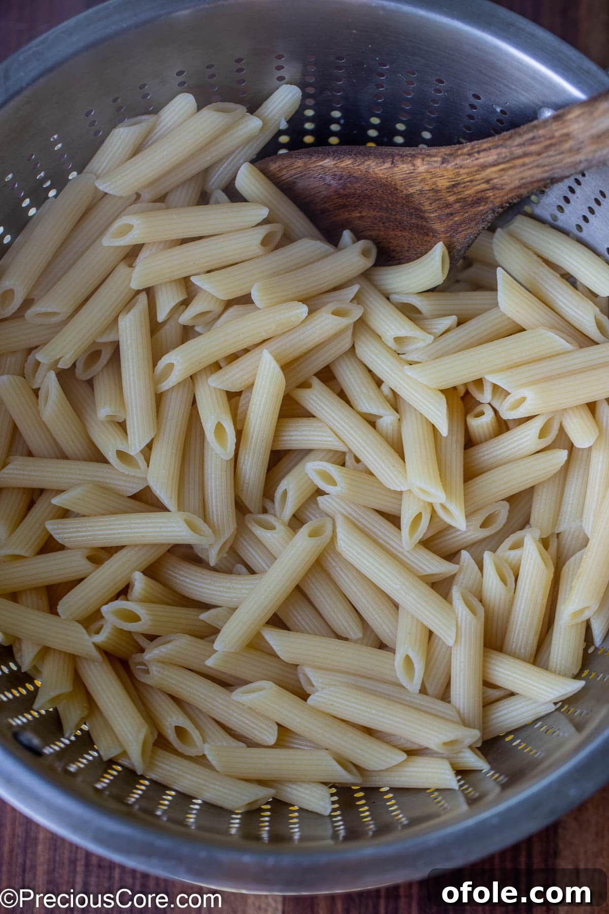 Parmesan Chicken Pasta with Garlic Cream Sauce 5 Drained cooked pasta resting in a stainless steel colander after cooking.