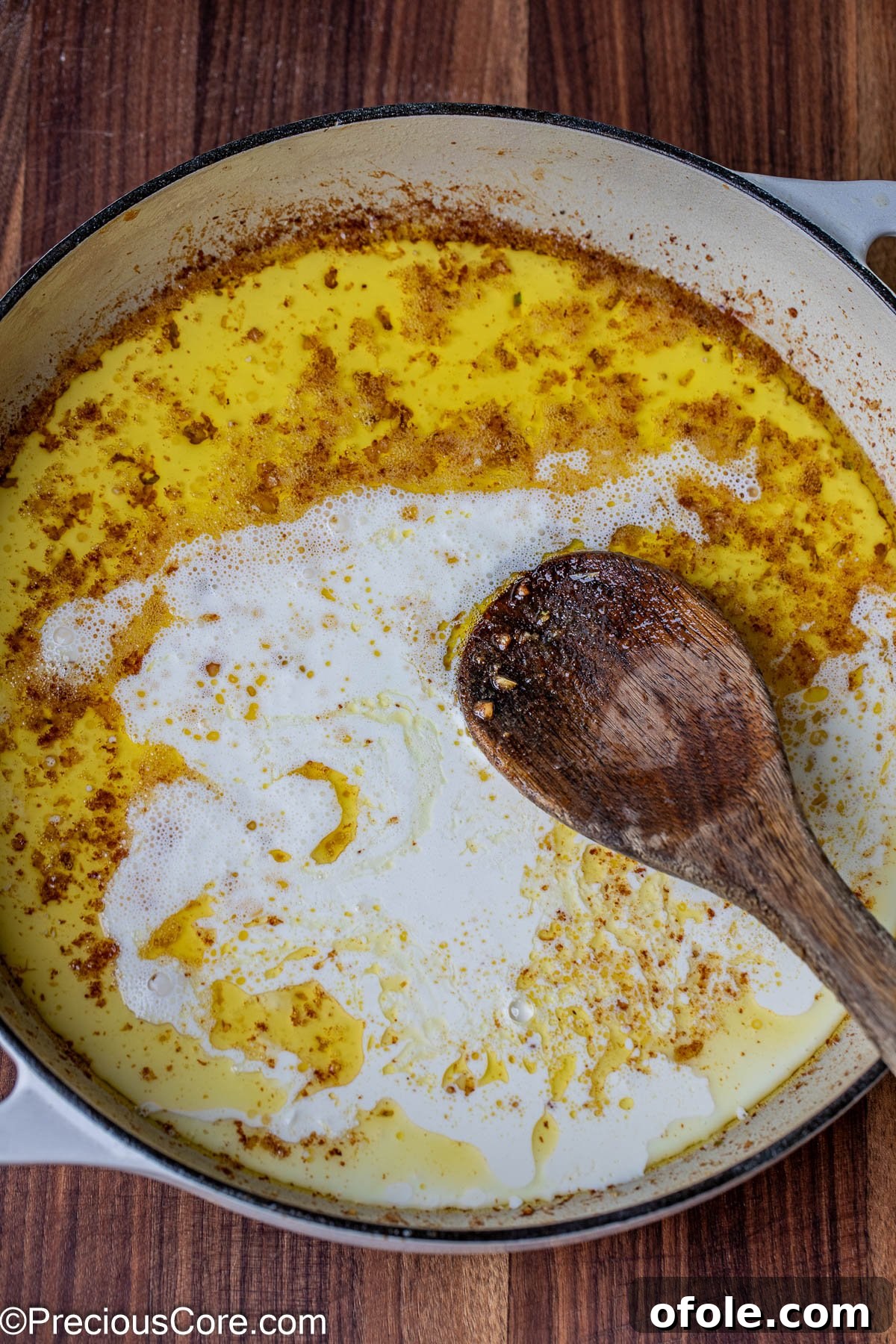 Parmesan Chicken Pasta with Garlic Cream Sauce 10 Heavy cream being poured into melted butter in the skillet.