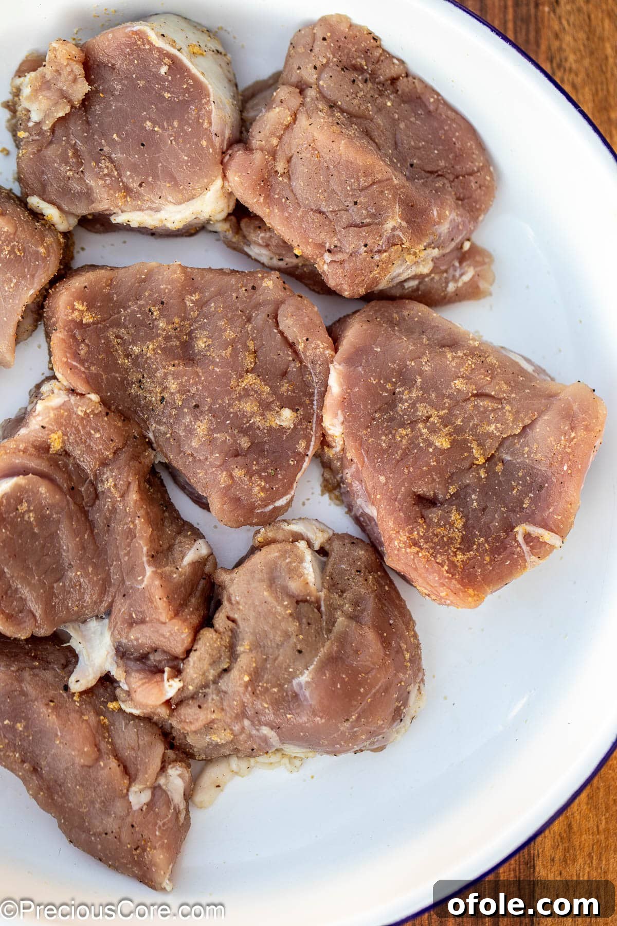 Pan-Seared Pork Tenderloin with Velvety Mushroom Sauce 7 Seasoned pork medallions in a white bowl.