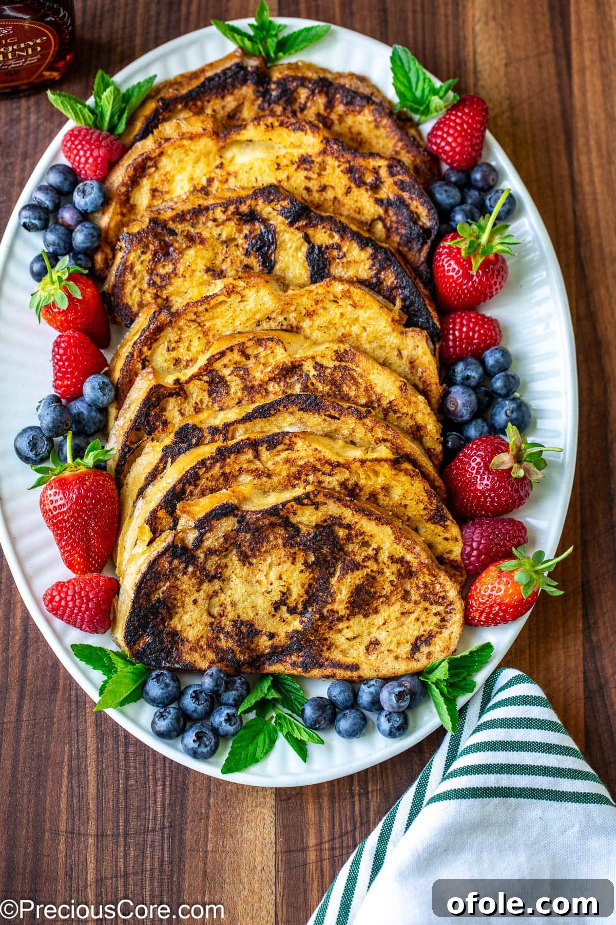 Elevated Sourdough French Toast 4 A delectable stack of French toast slices beautifully arranged on a rustic serving plate, inviting a perfect breakfast moment.