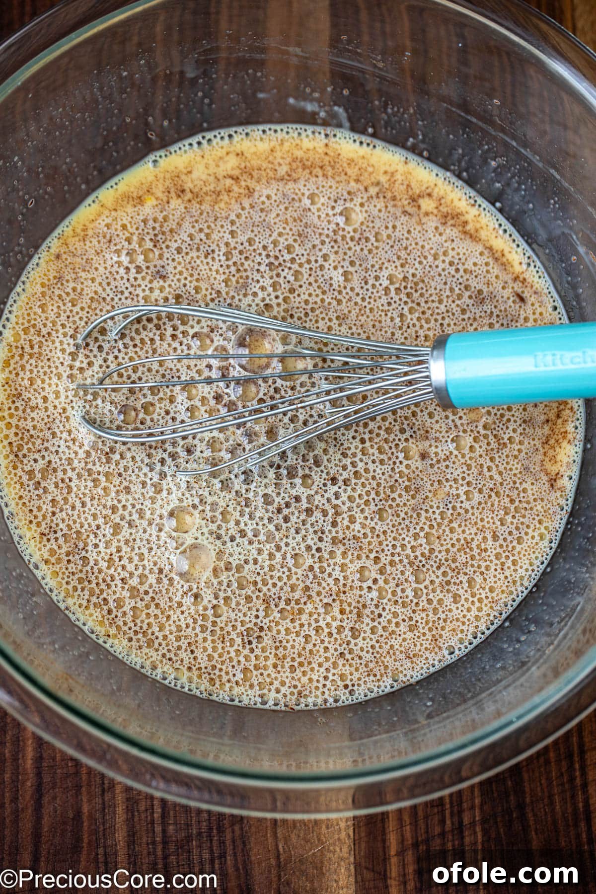 Elevated Sourdough French Toast 6 A large mixing bowl containing a creamy egg and milk mixture, ready for whisking with a metal whisk.