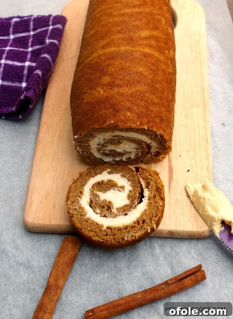 Spiced Pumpkin Swirl Cake 3 A beautifully crafted Pumpkin Roll Cake rests on a rustic wooden cutting board, ready for slicing and serving, embodying the essence of autumn baking.