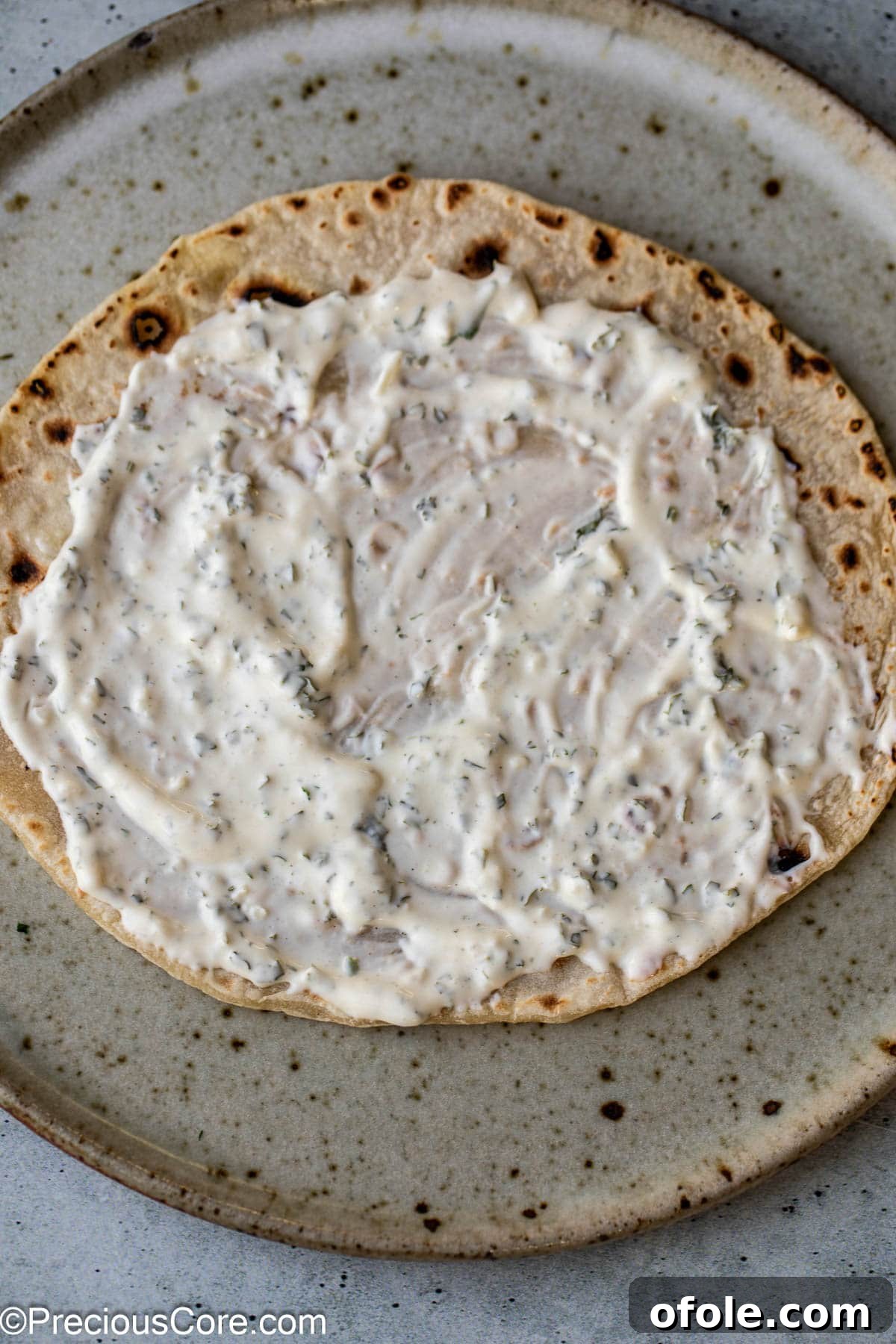 Authentic Shawarma Sauce 7 Shawarma sauce generously drizzled over a piece of warm flatbread.