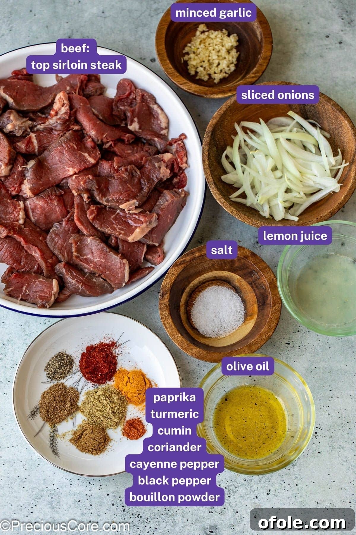 A selection of fresh ingredients including thinly sliced onions, spices, lemon, and beef, laid out for making beef shawarma.