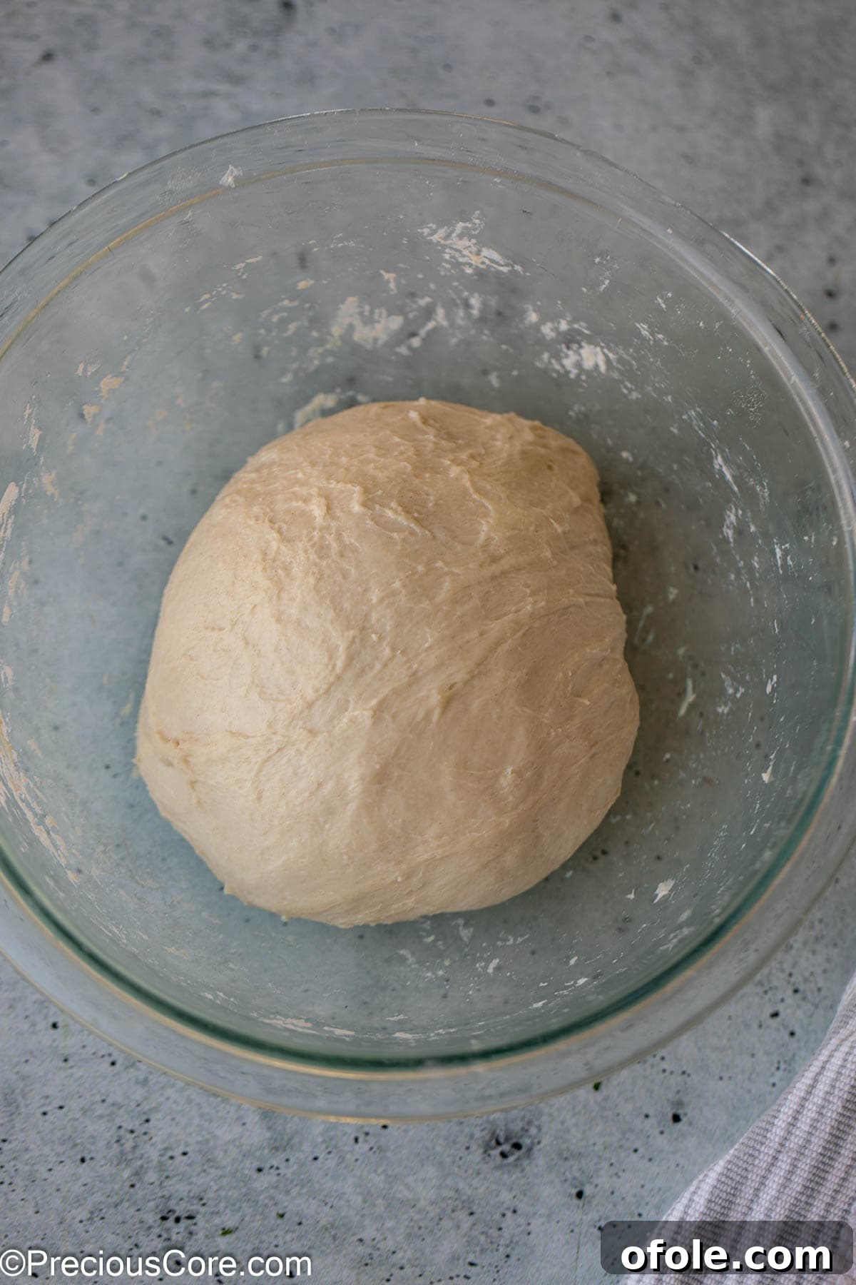 Shawarma Flatbread Delights 7 Perfectly smooth bread dough, glossy and elastic, shown in a clear glass bowl after kneading and resting.