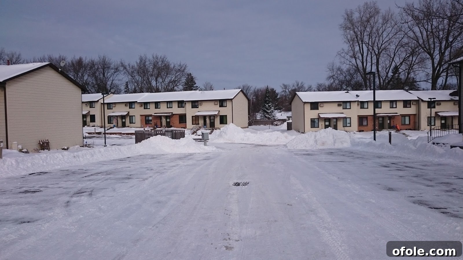Pictures Galore 9 A cleared residential street, with snow piled high on the sides, showcasing effective snow removal.