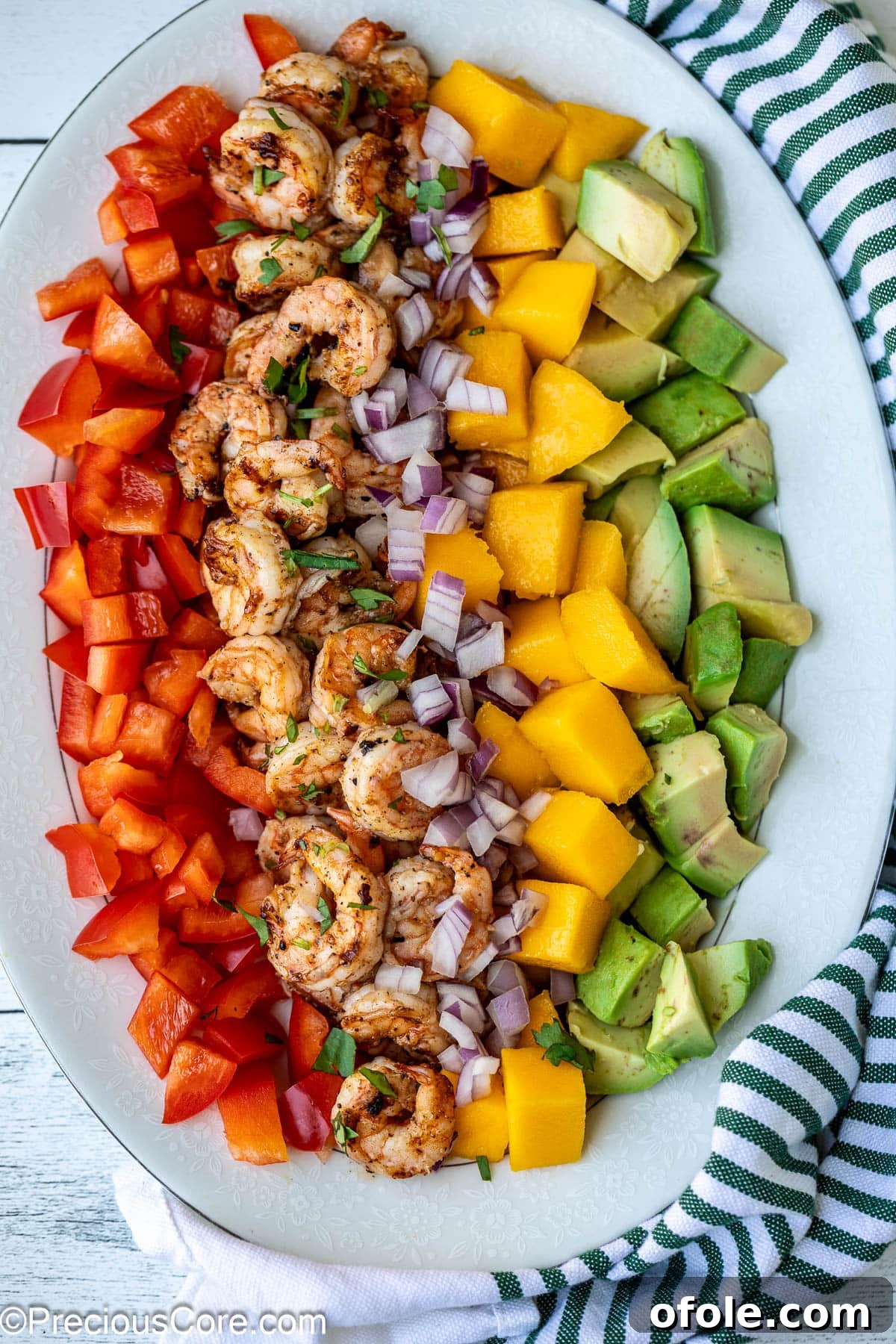 Tropical Mango Prawn Salad 2 Diced mango, cooked shrimp, creamy avocado, and vibrant bell peppers arranged beautifully in a bowl for a refreshing Mango Shrimp Salad.