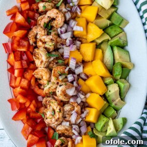 Diced mango, cooked shrimp, avocado, and bell peppers arranged beautifully for Mango Shrimp Salad.